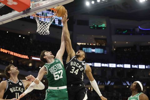 Milwaukee Bucks forward Giannis Antetokounmpo (34) puts up a shot against Boston Celtics' Mike Muscala (57) during an NBA basketball game, Tuesday, Feb. 14, 2023, in Milwaukee. (AP Photo/Jeffrey Phelps)