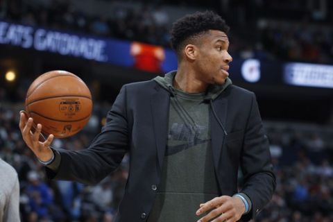 Milwaukee Bucks forward Giannis Antetokounmpo fields the ball as he shoots with teammates as they warm up for the second half of an NBA basketball game against the Denver Nuggets, Monday, March 9, 2020, in Denver. The Nuggets won 109-95. (AP Photo/David Zalubowski)