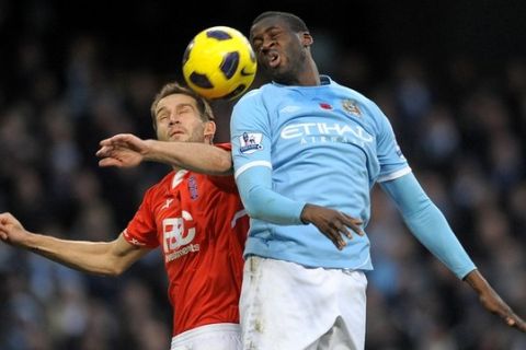 Manchester City's Ivorian defender Yaya Toure (R) vies with Birmingham City's English defender Roger Johnson (L) during the English Premier League football match between Manchester City and Birmingham City at the City Of Manchester Stadium in Manchester, north-west England on November 13, 2010. AFP PHOTO/ANDREW YATESFOR EDITORIAL USE ONLY Additional licence required for any commercial/promotional use or use on TV or internet (except identical online version of newspaper) of Premier League/Football League photos. Tel DataCo +44 207 2981656. Do not alter/modify photo. (Photo credit should read ANDREW YATES/AFP/Getty Images)