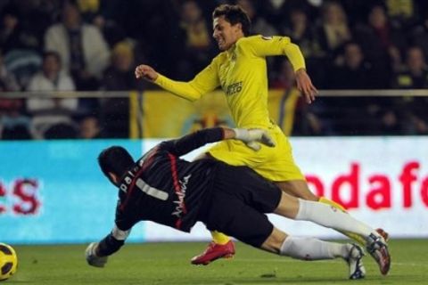 Villarreal's Nilmar Honorato from Brazil  duels to pass  the ball for a goal  with Sevilla's goalkeeper Andres Palop   during their La Liga soccer match at the Madrigal stadium in Villarreal, Spain, Sunday  Dec. 5, 2010. (AP Photo/Alberto Saiz) 