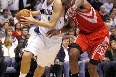 Dallas Mavericks power forward Dirk Nowitzki (L) drives on Houston Rockets forward Jordan Hill during the first half of their NBA basketball game in Dallas, Texas November 29, 2010.  REUTERS/Mike Stone (UNITED STATES - Tags: SPORT BASKETBALL)