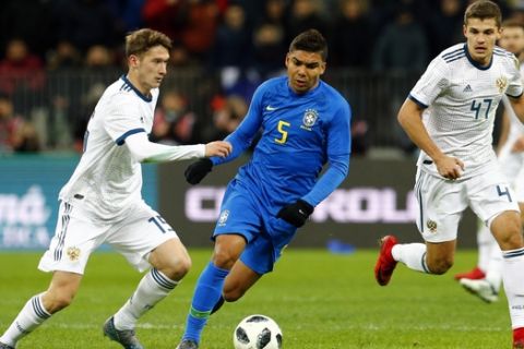 Russia's Aleksey Miranchuk, left, vies for the ball with Brazil's Casemiro during an international friendly soccer match between Russia and Brazil at the Luzhniki stadium in Moscow, Russia, Friday, March 23, 2018. (AP Photo/Alexander Zemlianichenko)