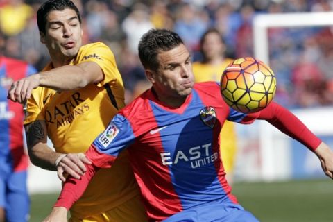 Barcelona's Luis Suarez, left,  duels for the ball with Levante's Tono Garcia  during a Spanish La Liga soccer match between Levante and Barcelona,  at the Ciutat de Valencia stadium in Valencia, Spain, Sunday, Feb. 7, 2016. (AP Photo/Alberto Saiz)