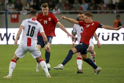 Norway's Martin Odegaard, right, and Norway's Alexander Sorloth, center, fight for the ball with Georgia's Nika Kvekveskiri during the Euro 2024 group A qualifying soccer match between Georgia and Norway at the AdjaraBet Arena in Batumi, Georgia, Tuesday, March 28, 2023. (AP Photo/Zurab Tsertsvadze)