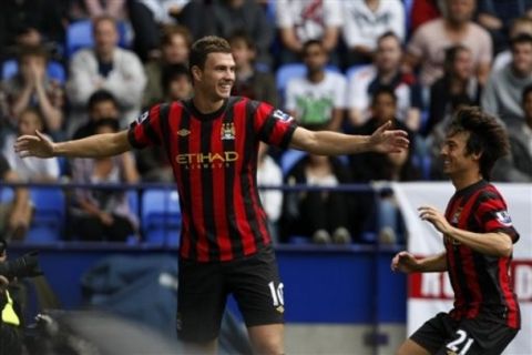 Manchester City's Edin Dzeko, left, celebrates with team mate David Silva after scoring a goal against Bolton during their English Premier League soccer match at the Reebok Stadium, Bolton, England, Sunday Aug. 21, 2011. (AP Photo/Tim Hales)