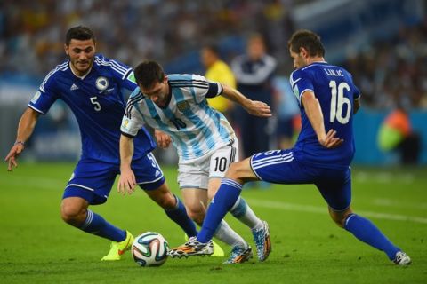 RIO DE JANEIRO, BRAZIL - JUNE 15:  Lionel Messi of Argentina controls the ball against Sead Kolasinac (L) and Senad Lulic of Bosnia and Herzegovina during the 2014 FIFA World Cup Brazil Group F match between Argentina and Bosnia-Herzegovina at Maracana on June 15, 2014 in Rio de Janeiro, Brazil.  (Photo by Matthias Hangst/Getty Images)