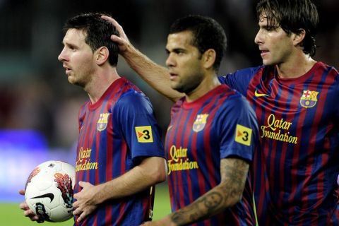 Barcelona's Argentinian forward Lionel Messi (L) leaves the pitch with a ball after scoring a hattrick during the Spanish league football match FC Barcelona vs Atletico de Madrid on September 24, 2011 at the Camp Nou stadium in Barcelona.   AFP PHOTO/ JOSEP LAGO (Photo credit should read JOSEP LAGO/AFP/Getty Images)