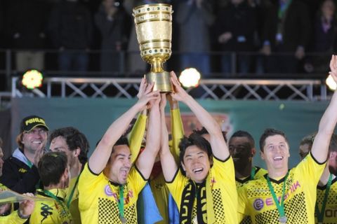 Dortmund's midfielder Ilkay Guendogan (C L) and Dortmund's Japanese forward Shinji Kagawa (C R) hold the trophy after the German cup " DFB Pokal " final football match Borussia Dortmund vs Bayern Munich at the Olympiastadion in Berlin on May 12, 2012. Dortmund defeated Munich 5-2.     AFP PHOTO / PATRIK STOLLARZ

RESTRICTIONS / EMBARGO - DFB LIMITS THE USE OF IMAGES ON THE INTERNET TO 15 PICTURES (NO VIDEO-LIKE SEQUENCES) DURING THE MATCH AND PROHIBITS MOBILE (MMS) USE DURING AND FOR FURTHER TWO HOURS AFTER THE MATCH. FOR MORE INFORMATION CONTACT DFB.PATRIK STOLLARZ/AFP/GettyImages