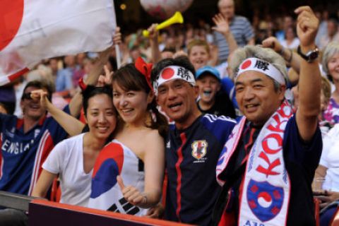 Japan and South Korea fans show their support in the stands prior to the men's football Bronze medal match between Japan and South Korea at the Millennium Stadium