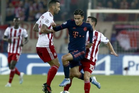 Bayern's Philippe Coutinho, centre, control the ball past Olympiakos' Daniel Podence, right, and Olympiakos' Guilherme during the Champions League group B soccer match between Olympiakos and Bayern Munich at the Georgios Karaiskakis stadium in Piraeus port, near Athens, Tuesday, Oct. 22, 2019. (AP Photo/Petros Giannakouris)