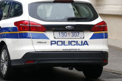 Police officers stand watch next to a police car on a street in Zagreb, Croatia, Monday Oct. 12, 2020 in the vicinity of a shooting incident. A gunman on Monday shot and wounded a police officer outside the Croatian government headquarters in the capital, Zagreb, before killing himself, police said. The shooting happened around 8 a.m. at Trg Svetog Marka, or St. Mark's Square, which hosts the Croatian parliament building and other other important state institutions. (AP Photo/Darko Bandic)