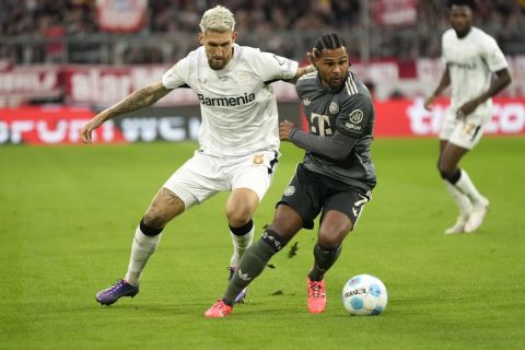 Leverkusen's Robert Andrich, left, and Bayern's Serge Gnabry vie for the ball during the Bundesliga soccer match between Bayern Munich and Leverkusen at the Allianz Arena in Munich, Germany, Saturday, Sept. 28, 2024. (AP Photo/Matthias Schrader)