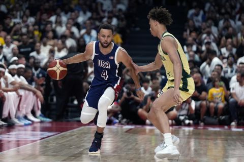 Team USA's Stephen Curry (4) drives on Australia's Dyson Daniels during the USA Basketball Showcase in Abu Dhabi, United Arab Emirates, Monday, July 15, 2024. (AP Photo/Altaf Qadri)