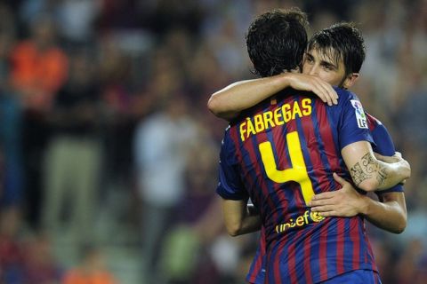 Barcelona's forward David Villa (R) is congratuled by his teammate Barcelona's midfielder Cesc Fabregas (L) after scoring during the Spanish league football match FC Barcelona vs Osasuna on September 17, 2011 at the Camp Nou stadium in Barcelona.  AFP PHOTO / JOSEP LAGO (Photo credit should read JOSEP LAGO/AFP/Getty Images)