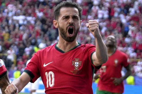 Portugal's Bernardo Silva, right, celebrates with Joao Cancelo after scoring the opening goal of his team, during a Group F match between Turkey and Portugal at the Euro 2024 soccer tournament in Dortmund, Germany, Saturday, June 22, 2024. (AP Photo/Themba Hadebe)