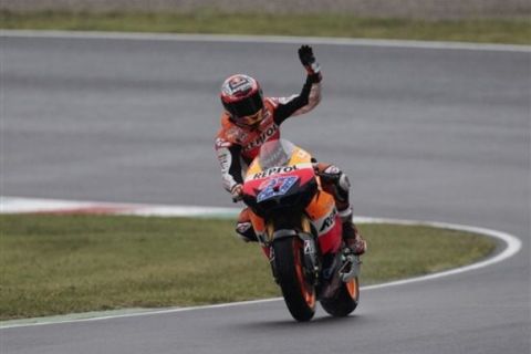 Honda rider Casey Stoner of Australia waves to fans after clocking the fastest time during the official practice session in view of Sunday's Italian Moto GP, at the Mugello racetrack, in Scarperia, Italy, Saturday, July 2, 2011. (AP Photo/Gregorio Borgia)