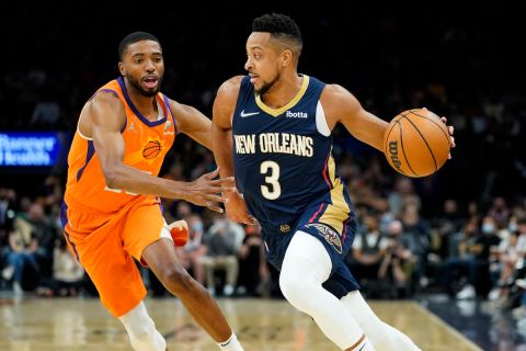 New Orleans Pelicans guard CJ McCollum (3) drives as Phoenix Suns forward Mikal Bridges defends during the first half of an NBA basketball game, Friday, Feb. 25, 2022, in Phoenix. (AP Photo/Matt York) 