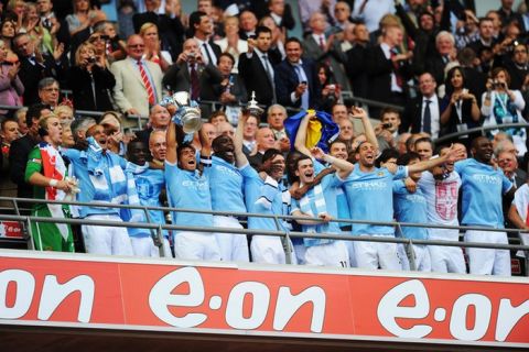 LONDON, ENGLAND - MAY 14:  Carlos Tevez lifts the trophy after he and his Manchester City team mates win the FA Cup sponsored by E.ON Final match between Manchester City and Stoke City at Wembley Stadium on May 14, 2011 in London, England. (Photo by Mike Hewitt/Getty Images)