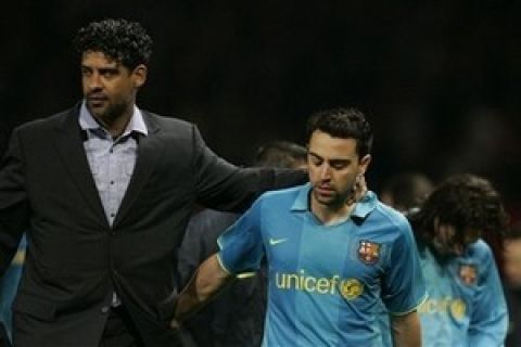 Barcelona's head coach Frank Rijkaard, left, consoles his player Xavi Hernandez beside Lionel Messi, right, after being defeated in their Champions League semifinal second leg soccer match against Mancheter United at Old Trafford stadium in Manchester, England, Tuesday April 29, 2008.  Manchester United went through to the final by winning the match 1-0.  (AP Photo/Paul Thomas) 