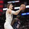 Utah Jazz's Lauri Markkanen, left, goes up for a shot as Houston Rockets' Usman Garuba (16) defends during the second half of an NBA basketball game Thursday, Jan. 5, 2023, in Houston. The Jazz won 131-114. (AP Photo/David J. Phillip)