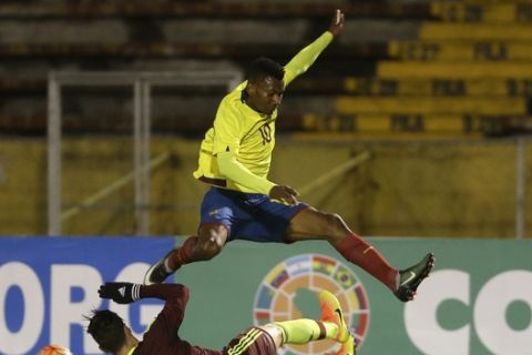 Ecuador's Bryan Cabezas jumps over Venezuela's Josue Mejia to avoid collision during a U-20 South America qualifying soccer tournament match for the 2017 South Korea U-20 World Cup, in Quito, Ecuador, Thursday, Feb. 2, 2017. (AP Photo/Dolores Ochoa)