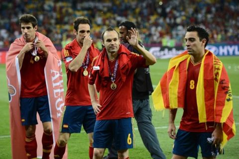 Spanish players (From L) Javi Martinez, Juanfran, Andres Iniesta and Xavi Hernandez gestures after winning the Euro 2012 football championships final match Spain vs Italy on July 1, 2012 at the Olympic Stadium in Kiev. AFP PHOTO / FRANCK FIFE        (Photo credit should read FRANCK FIFE/AFP/GettyImages)