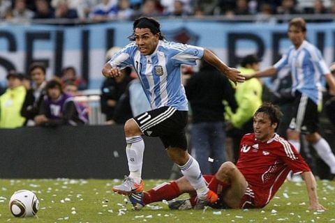 Argentina's Carlos Tevez (L) runs for the ball as Daniel Imhof of Canada looks on during their friendly soccer match in Buenos Aires, May 24, 2010. REUTERS/Santiago Pandolfi (ARGENTINA - Tags: SPORT SOCCER WORLD CUP)