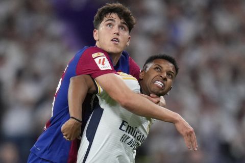 Real Madrid's Rodrygo, right, is challenged by Barcelona's Pau Cubarsi during the Spanish La Liga soccer match between Real Madrid and Barcelona at the Santiago Bernabeu stadium in Madrid, Spain, Sunday, April 21, 2024. (AP Photo/Manu Fernandez)