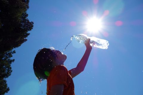 Child pouring water on himself.