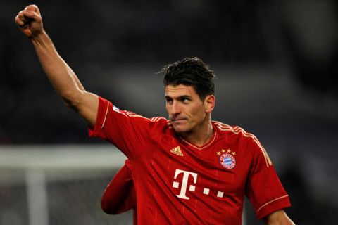 Munich's forward Mario Gomez raises his fist to celebrate after scoring during the German first division Bundesliga football match between  VfB Stuttgart and Bayern Muenchen at the Mercedes Benz Arena in Stuttgart, southern Germany, on December 11, 2011.     AFP PHOTO  THOMAS KIENZLE

RESTRICTIONS / EMBARGO - DFL LIMITS THE USE OF IMAGES ON THE INTERNET TO 15 PICTURES (NO VIDEO-LIKE SEQUENCES) DURING THE MATCH AND PROHIBITS MOBILE (MMS) USE DURING AND FURTHER TWO HOURS AFTER THE MATCH: FOR MORE INFORMATION CONTACT DFL. (Photo credit should read THOMAS KIENZLE/AFP/Getty Images)