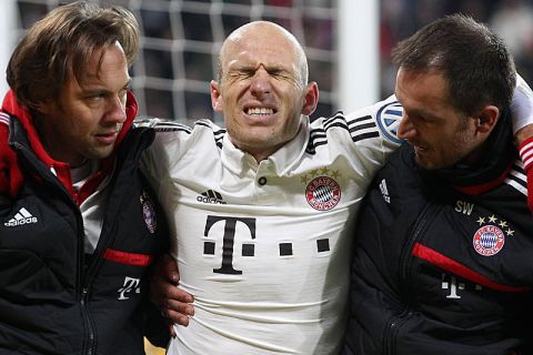 AUGSBURG, GERMANY - DECEMBER 04:  Arjen Robben (C) of Bayern Muenchen is assisted by team doctors after he was injured during their DFB Cup round of 16 match between FC Augsburg and FC Bayern Muenchen at SGL Arena on December 4, 2013 in Augsburg, Germany.  (Photo by Alexandra Beier/Bongarts/Getty Images)