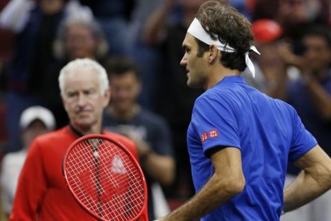 Team Europe's Roger Federer, right, walks past Team World's John McEnroe after winning a men's singles tennis match against Team World's John Isner at the Laver Cup, Sunday, Sept. 23, 2018, in Chicago. (AP Photo/Jim Young)