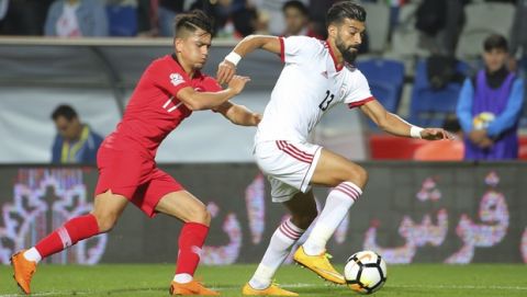 Turkey's Cengiz Under, left, tries to stop Iran's Ramin Rezaeian, right, during a friendly soccer match between Turkey and Iran, in Istanbul, Monday, May 28, 2018. (AP Photo)