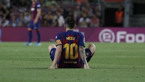 Barcelona's Lionel Messi sits on the ground after getting hurt during the Spanish La Liga soccer match between FC Barcelona and Villarreal CF at the Camp Nou stadium in Barcelona, Spain, Tuesday, Sep. 24, 2019. (AP Photo/Joan Monfort)