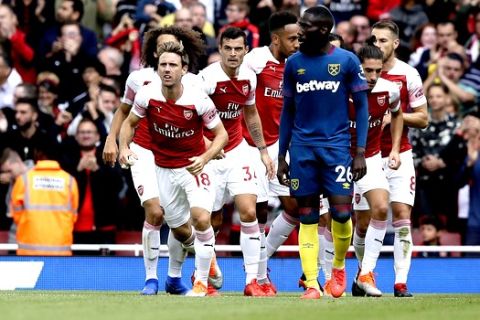 Arsenal's Nacho Monreal, celebrates past West Ham's Arthur Masuaku after scoring the equalizing goal during the English Premier League soccer match between Arsenal and West Ham United at the Emirates Stadium in London, Saturday Aug. 25, 2018. (AP Photo/Tim Ireland)