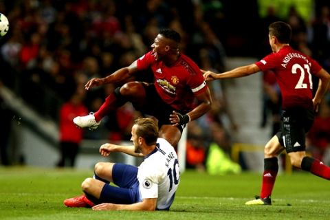 Tottenham Hotspur's Harry Kane, bottom left, fouls Manchester United's Antonio Valencia during the English Premier League soccer match between Manchester United and Tottenham Hotspur at Old Trafford stadium in Manchester, England, Monday, Aug. 27, 2018. (AP Photo/Dave Thompson)