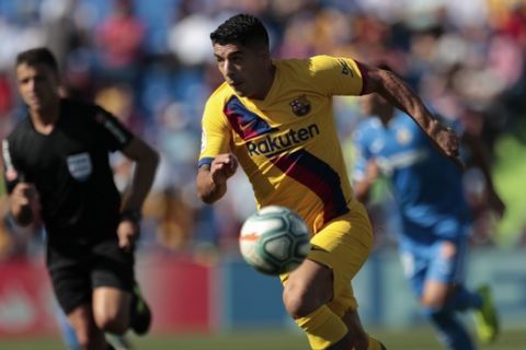 Barcelona's Luis Suarez runs with the ball during the Spanish La Liga soccer match between Getafe CF and FC Barcelona in Getafe, outskirts of Madrid, Spain, Saturday, Sept. 28, 2019. (AP Photo/Bernat Armangue)