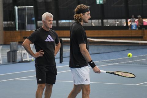 Stefanos Tsitsipas of Greece talks with his father and coach, Apostolos, left, during a practice session ahead of the men's final at the Australian Open tennis championship in Melbourne, Australia, Saturday, Jan. 28, 2023. Tsitsipas will play Novak Djokovic of Serbia in the final here Sunday Jan. 29.(AP Photo/Dita Alangkara)