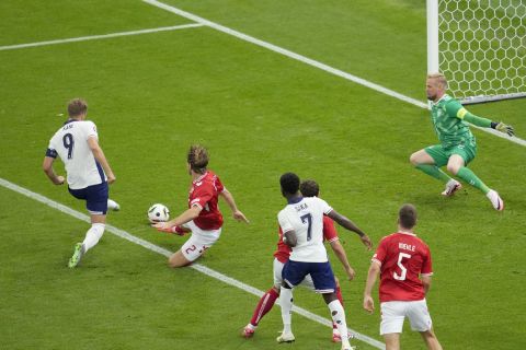 England's Harry Kane, left, scores the opening goal during a Group C match between Denmark and England at the Euro 2024 soccer tournament in Frankfurt, Germany, Thursday, June 20, 2024. (AP Photo/Darko Vojinovic)