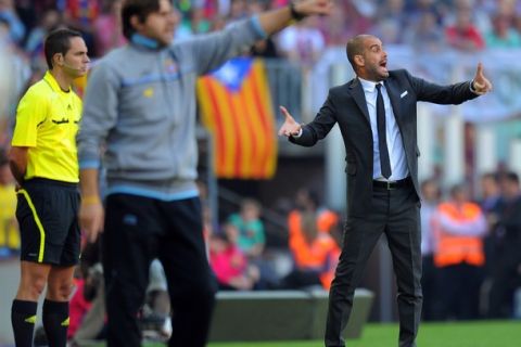 Barcelona's coach Pep Guardiola (R) and Espanyol's Argentinian coach Mauricio Pochettino (L) gesture during the Spanish League football match between FC Barcelona and RCD Espanyol on May 8, 2011 at Camp Nou stadium in Barcelona. AFP PHOTO/ LLUIS GENE (Photo credit should read LLUIS GENE/AFP/Getty Images)