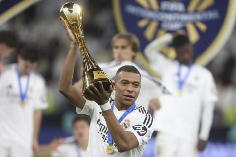 Real Madrid's Kylian Mbappe poses with the trophy after the Intercontinental Cup soccer final match against CF Pachuca at the Lusail Stadium in Lusail, Qatar, Wednesday, Dec. 18, 2024. Real Madrid won the game 3-0.(AP Photo/Hussein Sayed)