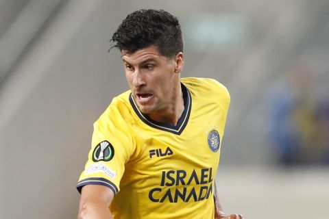 Maccabi Tel Aviv's Stipe Perica , left, and HJK Helsinki's Miro Tenho fight for the ball during a group A Europa Conference League soccer match between Maccabi Tel Aviv and HJK Helsinki in Tel Aviv, Israel, Thursday, Nov. 3, 2021. (AP Photo/Ariel Schalit)