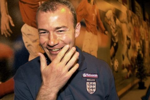 England's soccer captain Alan Shearer walks past pictures of the English team after a news conference on the EURO 2000 championship in the small town Spa in the south east of Belgium Thursday, June 15, 2000.  (AP Photo/Adam Butler)