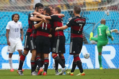 RECIFE, BRAZIL - JUNE 26:  Thomas Mueller of Germany celebrates scoring his team's first goal with teammates as Jermaine Jones (L) and Tim Howard of the United States react during the 2014 FIFA World Cup Brazil group G match between the United States and Germany at Arena Pernambuco on June 26, 2014 in Recife, Brazil.  (Photo by Robert Cianflone/Getty Images)