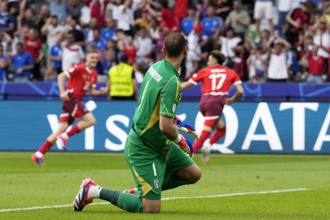 Italy's goalkeeper Gianluigi Donnarumma reacts after Switzerland's Ruben Vargas, background right, scored his side's second goal during a round of sixteen match between Switzerland and Italy at the Euro 2024 soccer tournament in Berlin, Germany, Saturday, June 29, 2024. (AP Photo/Antonio Calanni)