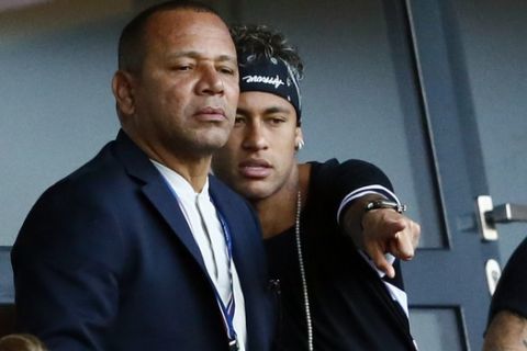 Paris Saint-Germain's, Brazilian soccer star Neymar, right, flanked by his father Neymar Santos, left, watches the match at the Parc des Princes stadium in Paris, Saturday, Aug. 5, 2017, after his official presentation to fans ahead of Paris Saint-Germain's season opening match against Amiens. Neymar would not play in the club's season opener as the French football league did not receive the player's international transfer certificate before Friday's night deadline. The Brazil star became the most expensive player in soccer history after completing his blockbuster transfer from Barcelona for 222 million euros ($262 million) on Thursday. (AP Photo/Francois Mori)