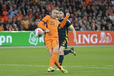 Netherlands' Teun Koopmeiners attempts a shot at goal in front of Scotland's Andrew Robertson during an international friendly soccer match between Netherlands and Scotland at the Johan Cruyff ArenA, in Amsterdam, Netherlands, Friday, March 22, 2024. (AP Photo/Peter Dejong)