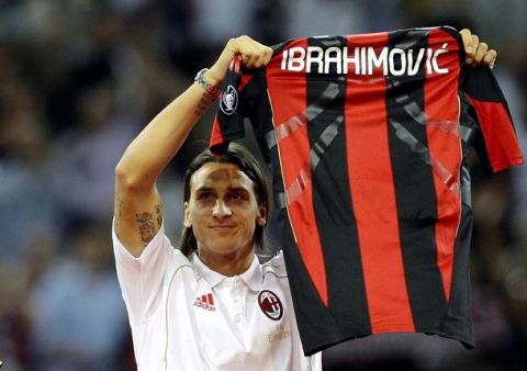 Swedish soccer player Zlatan Ibrahimovic holds an AC Milan jersey during a presentation during the Italian Serie A soccer match between AC Milan and Lecce at the San Siro stadium in Milan August 29, 2010. REUTERS/Alessandro Garofalo (ITALY - Tags: SPORT SOCCER)