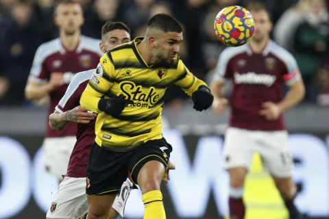 Watford's Imran Louza, heads the ball as West Ham's Manuel Lanzini chases him during an English Premier League soccer match between West Ham United and Watford at the London stadium in London, Tuesday, Feb. 8, 2022. (AP Photo/David Cliff)