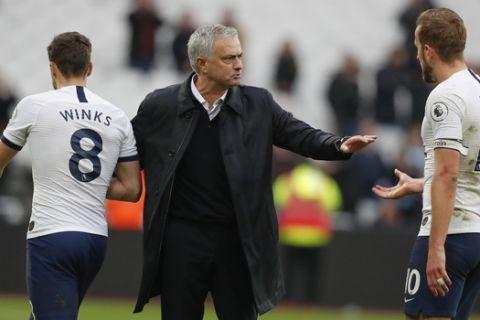 Tottenham's manager Jose Mourinho, center, talks with Tottenham's Harry Winks, left, and Harry Kane at the end of the English Premier League soccer match between West Ham and Tottenham, at London stadium, in London, Saturday, Nov. 23, 2019.(AP Photo/Frank Augstein)